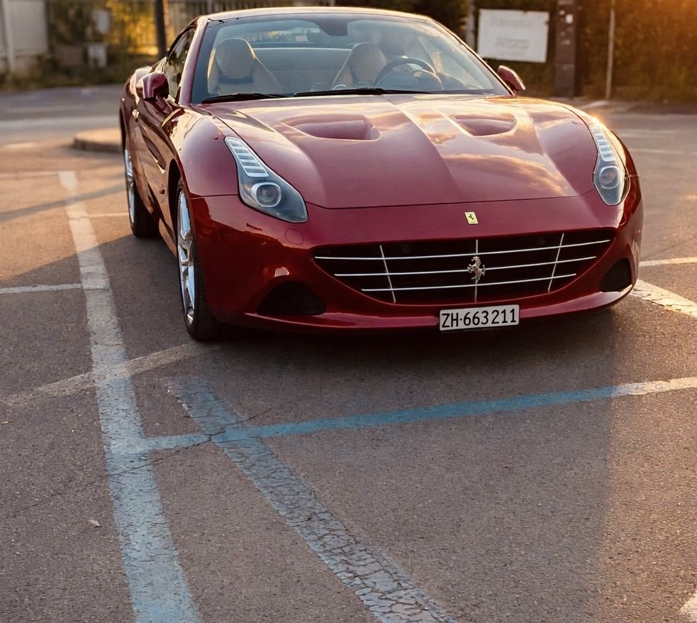 Supercar rossa al tramonto in un parcheggio