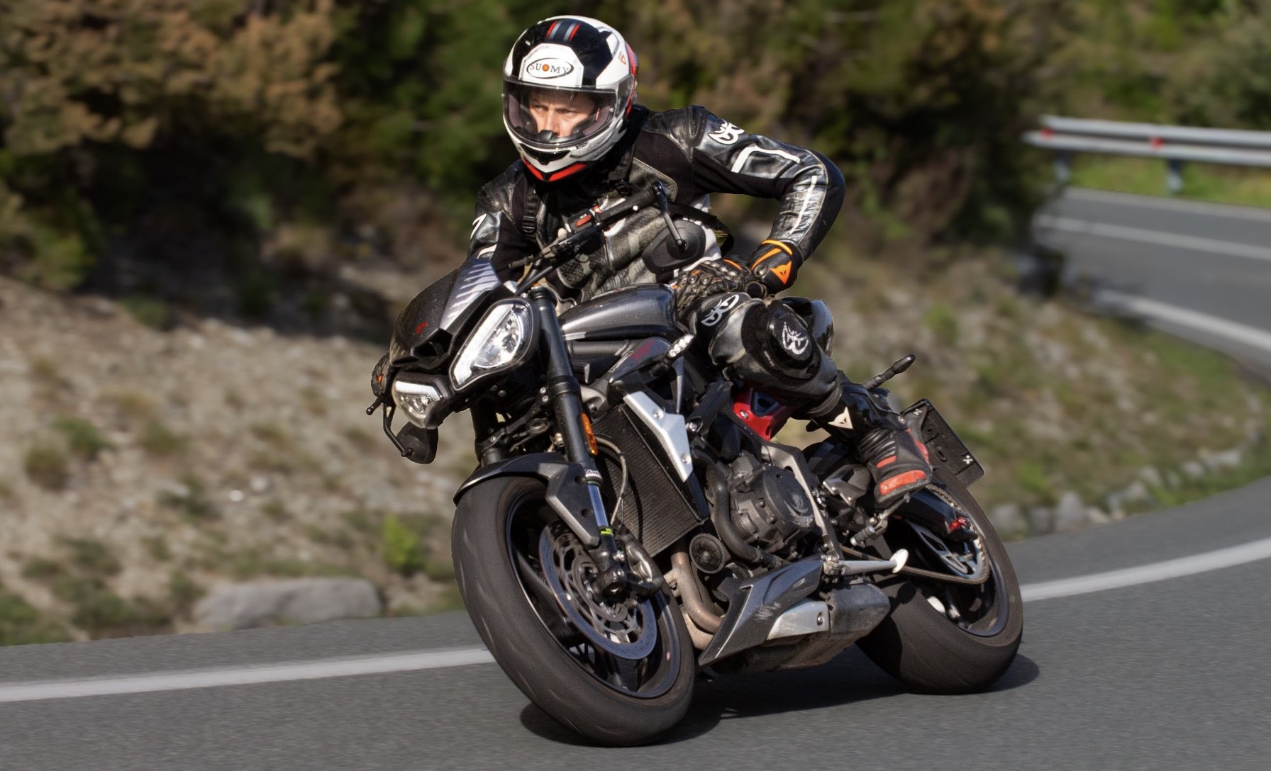 Motociclista in piega su una strada di montagna